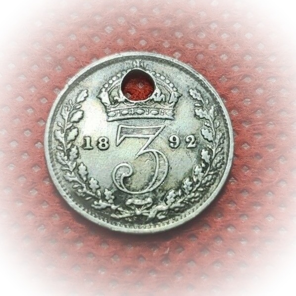 Photograph of a threepenny piece from 1892 with a hole in it